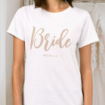 Camiseta Noiva Nome Personalizado Beige White<br><div class="desc">Celebre a noiva a ser com uma camiseta personalizada única! Um design simples e na moda com letra de script de tendência e personalizado com o nome da noiva, data do casamento, local ou outro texto. Esta camiseta branca e beige na moda, faz um belo presente para um fim de...</div>
