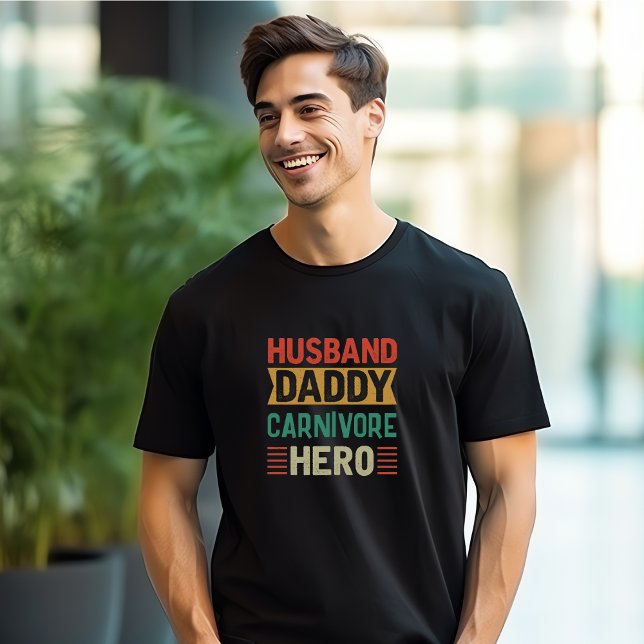 Camiseta Personalizável para o Herói do Carnívoro do Pai Ma (Man wearing a black t-shirt with colorful words "Husband, Daddy, Carnivore, Hero")