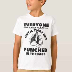 Camiseta Todos Têm Um Plano Até Levarem Um Soco No