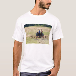 Camiseta Um menino novo que conduz uma colheita do trator