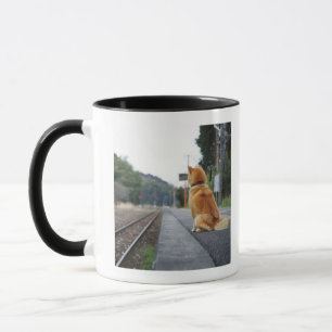 Caneca Cão que senta-se no estação de caminhos-de-ferr