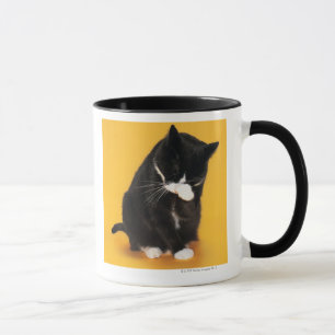 Caneca Cara preto e branco da limpeza do gato com pata