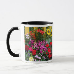 Caneca Cerca de estacas amarelas com jardim de flores em