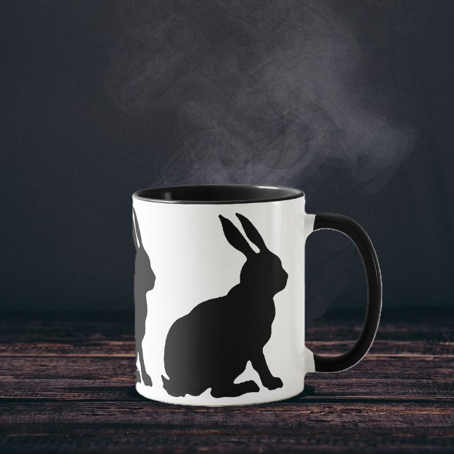 Caneca Coelhos Silhueta Preta (Ring of sitting black silhouette rabbits with tall ears on white coffee or tea mug.)