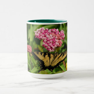 Caneca da borboleta com flores do milkweed
