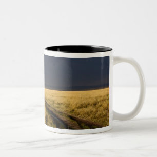 Caneca De Café Em Dois Tons Nuvens de tempestade e estrada através das planíci