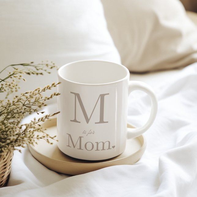 Caneca De Café Esquema de Letra de Amor (“White mug with taupe lettering, oversized serif initial, script accent, bold ‘Mom,’ and heart.”)