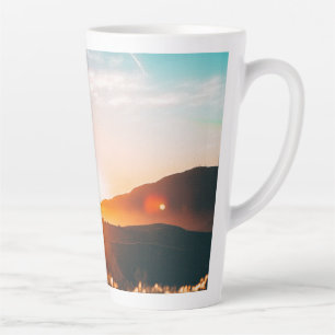 Caneca De Café Latte nascer do sol sobre uma montanha