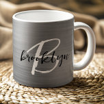 Caneca De Café Monograma de Script Branco Preto, Bruto, em Prata<br><div class="desc">Esta elegante caneca de café personalizada apresenta um monograma e primeiro nome em uma escrita moderna em preto e branco sobre um fundo de metal vermelho prateado.</div>