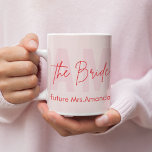Caneca De Café Mug de noivo personalizado | Blush Pink Future Sra<br><div class="desc">Sip em estilo com esta elegante caneca de noiva personalizada, desenhada com um monograma roxo, um roteiro "A Noiva" na moda, e o nome personalizável do futuro Sra. É o noivado, chá de panela ou presente de solteira perfeito que é significativo e funcional. Um lembrete chic matinal de amor, risos...</div>