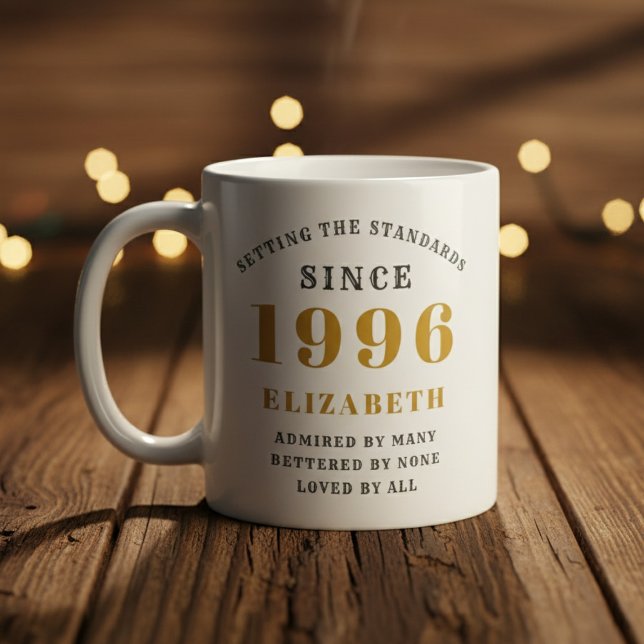 Caneca De Café Personalizado Aniversário de 30 anos 1996 Adiciona (Born 1996 birthday gift mug on a woof floor. Blurred background.)