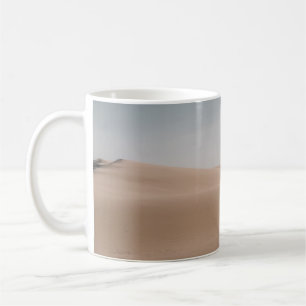 CANECA DE CAFÉ PESSOA CAMINHANDO NA AREIA MARROM DURANTE O DIA