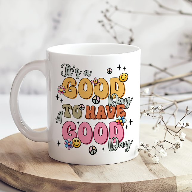 Caneca De Café Retro Positividade "É um bom dia" (Retro Positivity "It's a Good Day" Coffee Mug on a boho table with tiny dry white flowers)