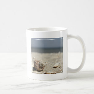 Caneca De Café Seashells na areia pelo mar