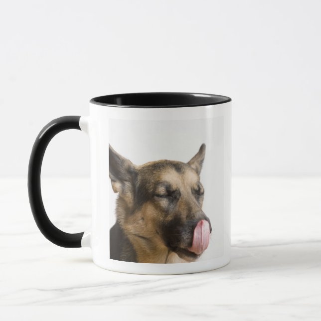 Caneca Fim-acima de um german shepherd que lambe seu (Esquerda)