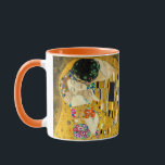 Caneca Gustav Klimt - O Beijo / Dia de os namorados<br><div class="desc">O Beijo (em alemão Der Kuss) é uma pintura de óleo na canvas com folhas de ouro, prata e platina adicionadas pelo pintor simbolista austríaco Gustav Klimt. A pintura retrata um casal que se abraça, seus corpos entrelaçados em lindas e elaboradas vestes decoradas num estilo influenciado pelo estilo contemporâneo Art...</div>