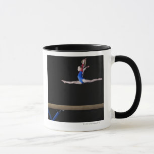 Caneca Gymnast (9-10) que pula no feixe de equilíbrio 2