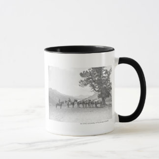 Caneca Homens com os packhorses que olham sobre um monte