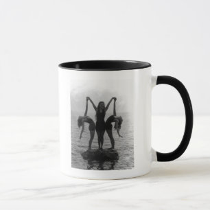 Caneca Meninas no levantamento em uma rocha na água