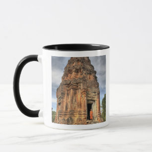Caneca Monge budista em pé na porta do templo