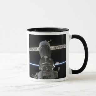 Caneca O membro da terra cruza uma nave espacial de Soyuz