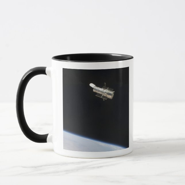 Caneca O Telescópio Espacial Hubble em órbita acima da Te (Esquerda)