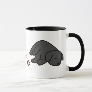 Caneca preta sonolento do filhote de cachorro do