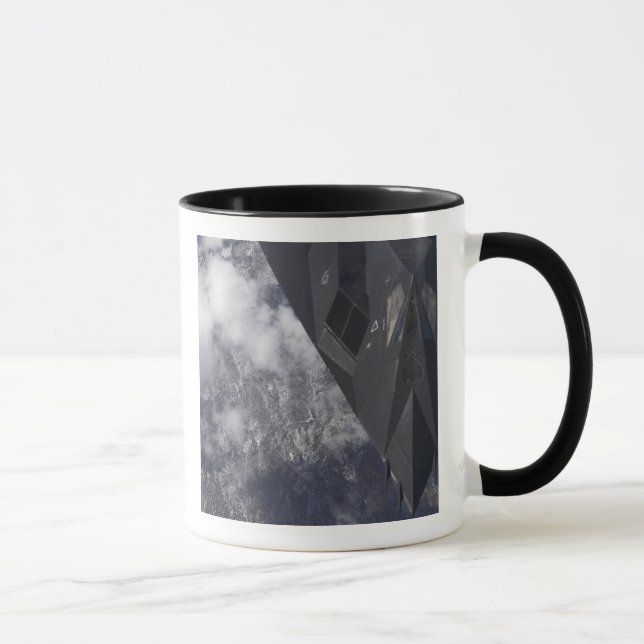 Caneca Um F-117A Nighthawk voa alto sobre a montanha (Direita)