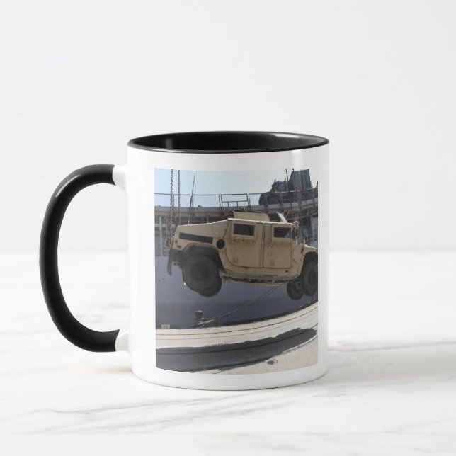 Caneca Um guindaste levanta um Humvee M998 (Esquerda)