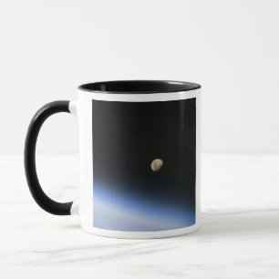 Caneca Uma lua gibbous visível acima da atmosfera de