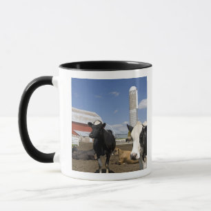 Caneca Vacas em frente a um celeiro vermelho e silo em um