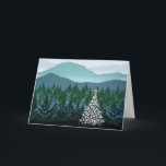 Cartão azul do Natal de Ridge<br><div class="desc">Um pinheiro solitário com luzes brancas está em uma floresta com as montanhas no fundo. Os fotograma da folha formam o primeiro plano e as formas de papel rasgadas as montanhas na distância. a aplicação da tinta da Separação-fonte no silkscreen original dá a ilusão da névoa nos vales. A árvore...</div>