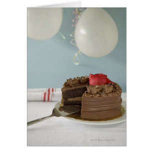 Cartão Bolo de chocolate com fatia faltante na mesa,