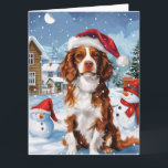 Cartão Brittany Spaniel Dog Winter Wonderland Natal<br><div class="desc">Este design festivo captura o espírito alegre da época de férias, apresentando um adorável filhote vestindo um chapéu de Papai Noel. O cachorro está aninhado numa terra maravilhosa de inverno, completo com um boneco de neve, uma árvore de Natal decorada, e presentes lindamente envoltos. Os flocos de neve caem suavemente,...</div>