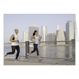 Cartão Casal rodando no píer com a cidade em segundo plan