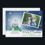 Cartão com fotos Bonito de Snowman Feliz Natal<br><div class="desc">O cartão com fotos de férias bonito apresenta a sua foto favorita da família. "Feliz Natal" aparece em uma tipografia de roteiro preto na frente. Abaixo, você pode personalizar este cartão com seu próprio nome familiar. O fundo tem um fundo azul com flocos de neve brancos. Para personalizá-lo, clique em...</div>