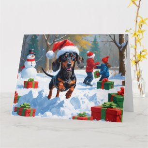 Cartão Dachshund Correndo na Neve com Chapéu de Natal