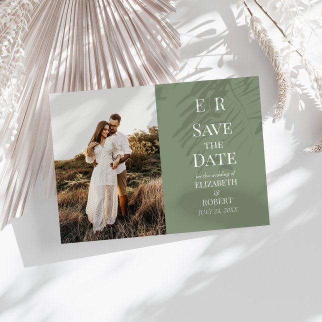 Cartão de Data de Salvamento de Foto Monograma de  (Modern Olive Monogram Photo Save the Date Card on a sunny white table with neutral dry botanicals.)