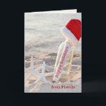 Cartão De Festividades Boas festas mensagem em uma garrafa<br><div class="desc">Boas festas mensagem em uma garrafa com estrela do mar e o chapéu peludo do papai noel na praia</div>