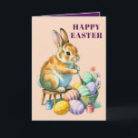 Cartão De Festividades Cute Bunny Painting Easter Eggs Greeting Card<br><div class="desc">This charming Easter card features an adorable vintage-style bunny perched on a stool carefully painting colorful Easter eggs with tiny paint jars by its side. The soft peach background and whimsical illustration give this card a nostalgic storybook feel that's impossible not to love. It's the perfect card to send to...</div>