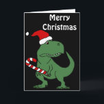 Cartão De Festividades Dinossauro bonito de T-rex na arte do Natal do<br><div class="desc">O dinossauro verde engraçado legal de T-rex no chapéu do papai noel com arte original do Natal dos desenhos animados do bastão de doces é fantástico para amantes do dinossauro e para festas natalícias do Natal.</div>