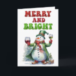 Cartão De Festividades Feliz e Bright Snowman<br><div class="desc">Uma design de Natal engraçada e alegre mostra um boneco de neve alegre vestido em um longo casaco verde com um chapéu igual, lenço vermelho e luvas. Ele segura uma taça de vinho tinto em uma mão e vinho branco na outra. O texto festivo vermelho e verde diz, "Feliz e...</div>