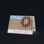 Cartão De Festividades Grinalda da praia da baga do Natal na cerca<br><div class="desc">grinalda da baga na cerca da praia com dólar da estrela do mar e de areia com fundo da água.
Beira rasgada da borda adicionada.</div>