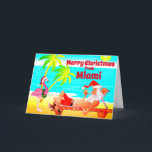 Cartão De Festividades Miami Felry Papais noeis de Natal e Flamingo Beach<br><div class="desc">Este cartões de natal de Feliz Natal apresenta Santa Clause em Miami Beach. Ele está relaxando aproveitando o sol, palmeiras, seu cachimbo e um flamingo rosa engraçado vestindo um chapéu e uma coroa de Papai Noel. Saudação dentro ~ "Desejos mais quentes do nosso Paraíso Feriado para o seu... ". Todo...</div>