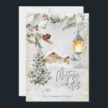 Cartão De Festividades O Natal está no Air Winter Trees Cabin<br><div class="desc">Uma floresta de inverno nevada com árvores e folhas congeladas e bagas com o brilho quente de uma lanterna e a tipografia do Natal está no Ar com efeito de brilho prateado. Personalize facilmente o seu nome na frente e as suas saudações e nomes no verso.</div>