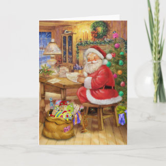 Cartão De Festividades Papai Noel que trabalha em sua mesa