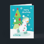 Cartão De Festividades Patinagem no gelo do boneco de neve do Natal do<br><div class="desc">Envie a um Godson especial um divertimento e um cartão de Natal colorido que caracterizam um boneco de neve feliz do patinagem no gelo com uma árvore colorida e flocos de neve em um fundo de turquesa. Cortesia do boneco de neve de Grafik bonito.</div>