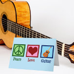 Cartão De Festividades Violão de Paz<br><div class="desc">Um legal cartão de Natal guitarrista,  com um cartaz de paz,  coração e uma guitarra sobre um belo fundo azul. Um cartão de feriado de loja de instrumentos musicais que lê o Violão do Amor pela Paz.</div>