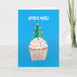 Cartão de Natal, cupcake francês com árvore de<br><div class="desc">Um cartão de Natal francês brilhante e alegre com uma árvore de Natal decorada sobre um cupcake congelado, de uma colagem de papel pintado à mão por Judy Adamson. O cumprimento dianteiro, no texto branco em um fundo azul, é "Joyeux Noel!" e a mensagem interna, que você pode mudar, é,...</div>