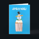 Cartão de Natal, Francês, Cupcake com Snowman<br><div class="desc">Um cartão de Natal francês brilhante e alegre com um boneco de neve decorado e sagrado em cima de um cupcake gelado, de uma colagem de papel pintada à mão por Judy Adamson. A saudação frontal, em texto branco sobre fundo azul, é 'Joyeux Noel!' e a mensagem dentro, que você...</div>